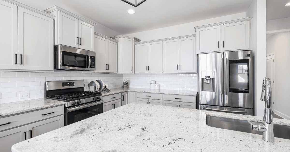kitchen with white cabinets, silver appliances, and granite countertops
