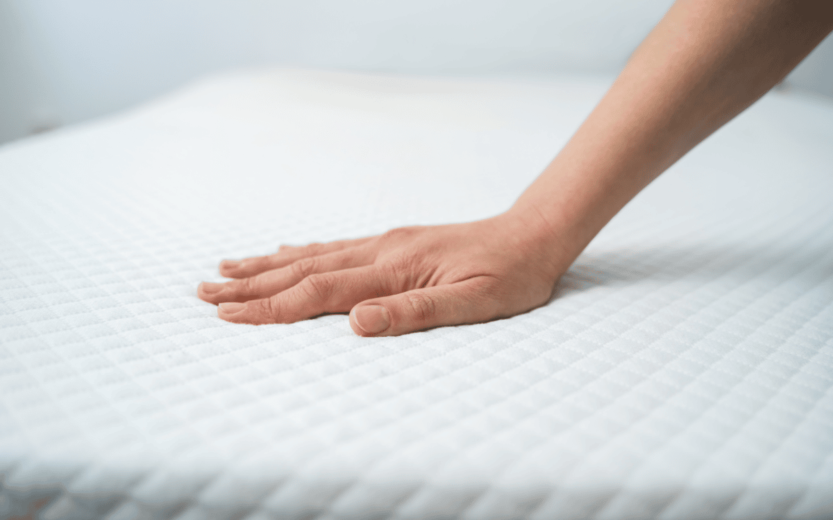 woman's hand on damp mattress