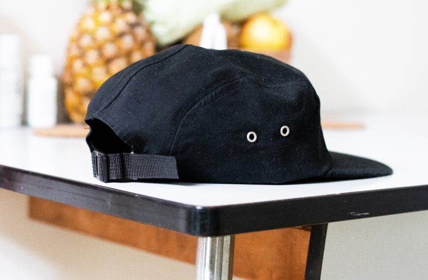 black ball cap on white counter with pineapple in background